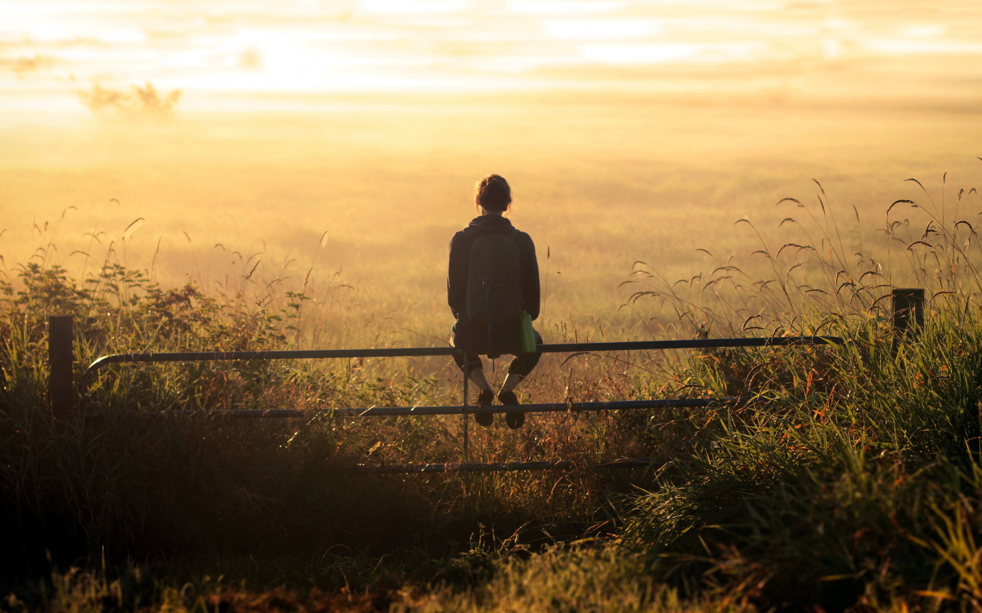girl-backpack-thinking-sunset-field-fence-