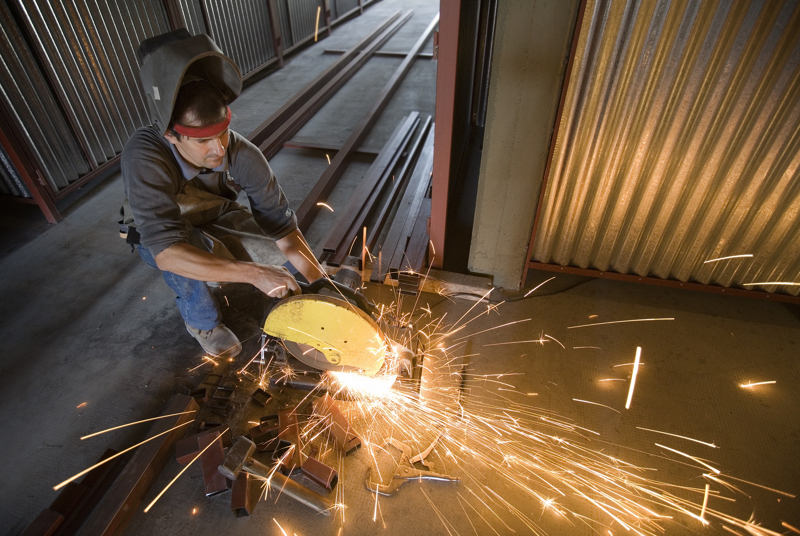 Construction worker cutting iron beams in a structure