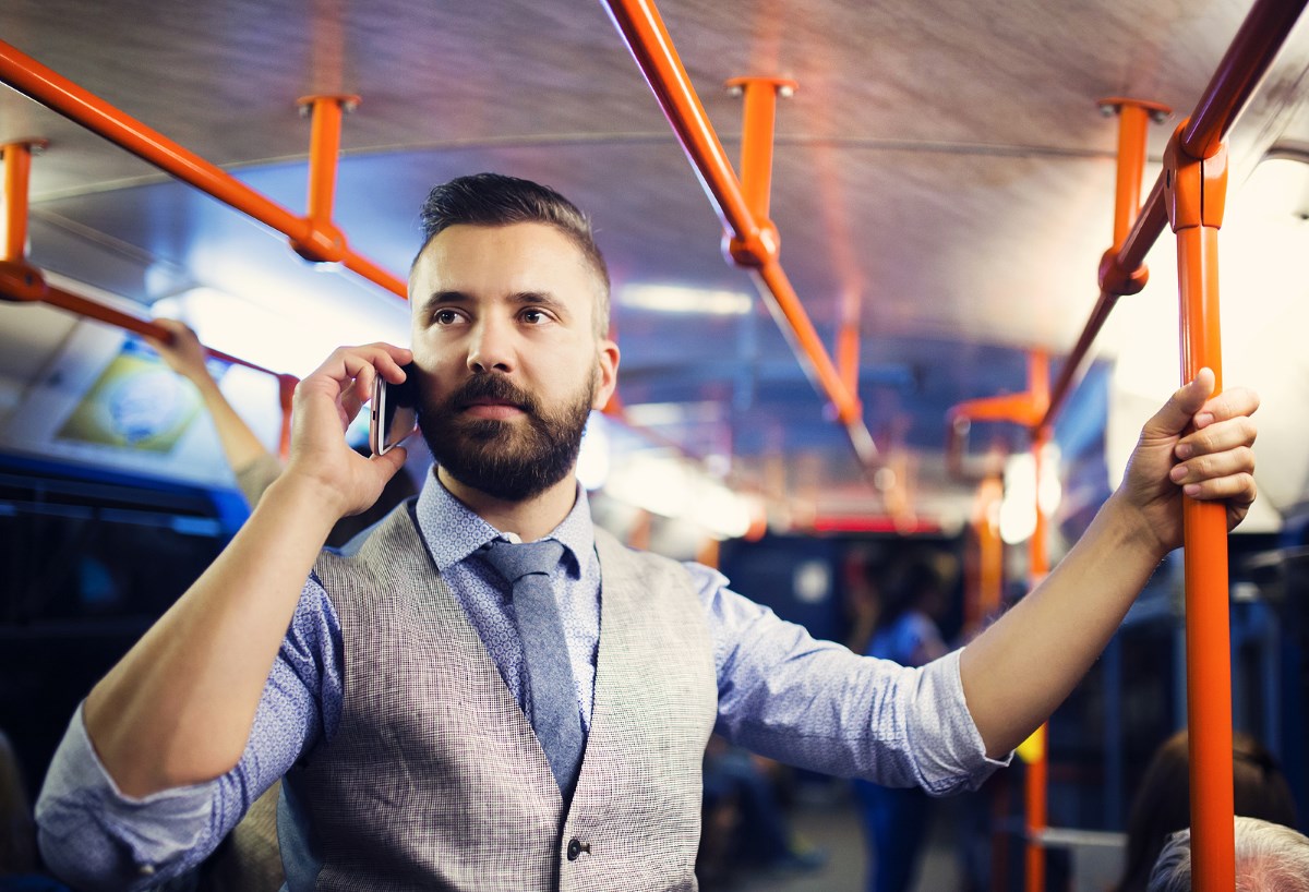 Handsome hipster modern man calling by mobile phone in tram in night