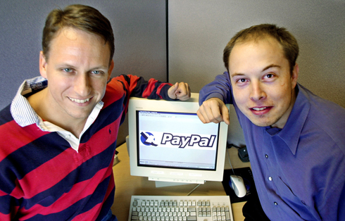 FILE - In this Oct. 20, 2000 file photo, PayPal Chief Executive Officer Peter Thiel, left, and founder Elon Musk, right, pose with the PayPal logo at corporate headquarters in Palo Alto, Calif. Thiel who who co-founded PayPal and gave Facebook its first big investment now wants Silicon Valley to buy into a bigger idea: the future. Thiel is backing groups that see a future when computers will communicate directly with the human brain. Seafaring pioneers will found new floating nations in the middle of the ocean. Science will conquer aging, and death will become a curable disease. (AP Photo/Paul Sakuma, File)