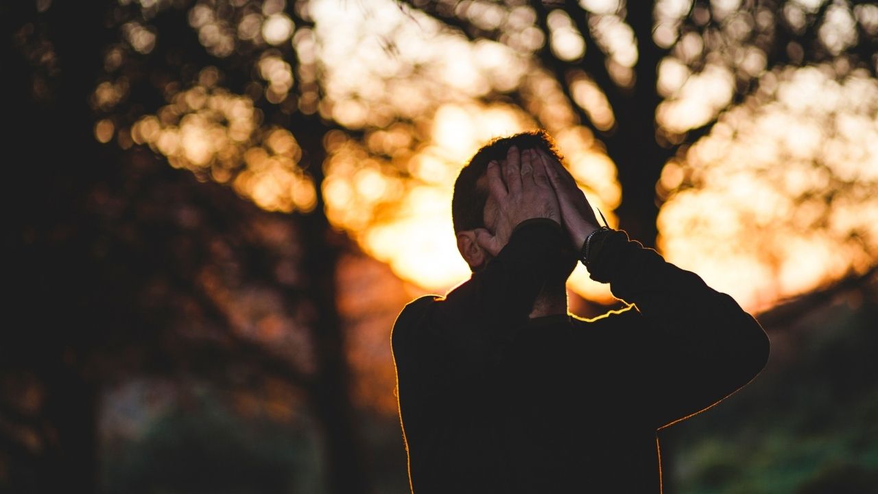 muž s rukami na tvári