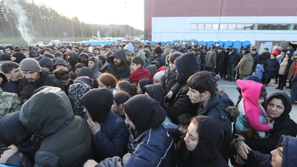 Migranti stoja pred logistickým centrom neďaleko mesta Hrodna na bielorusko-poľských hraniciach