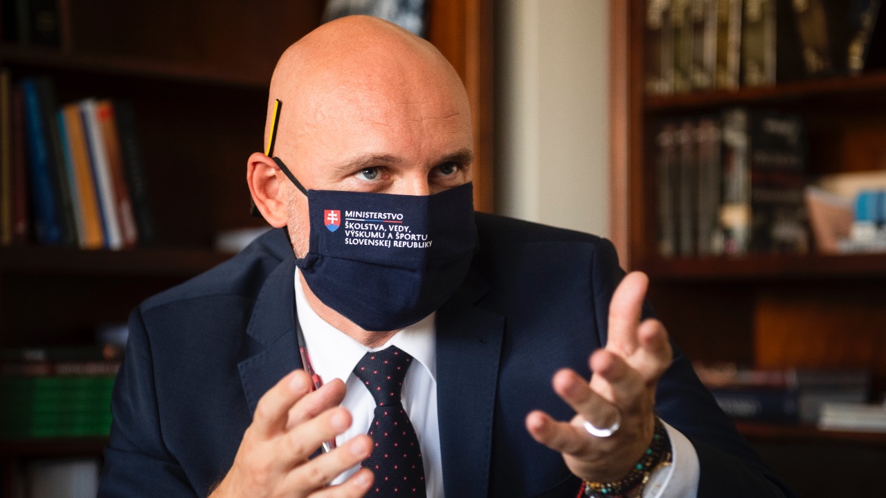 Minister školstva gestikuluje