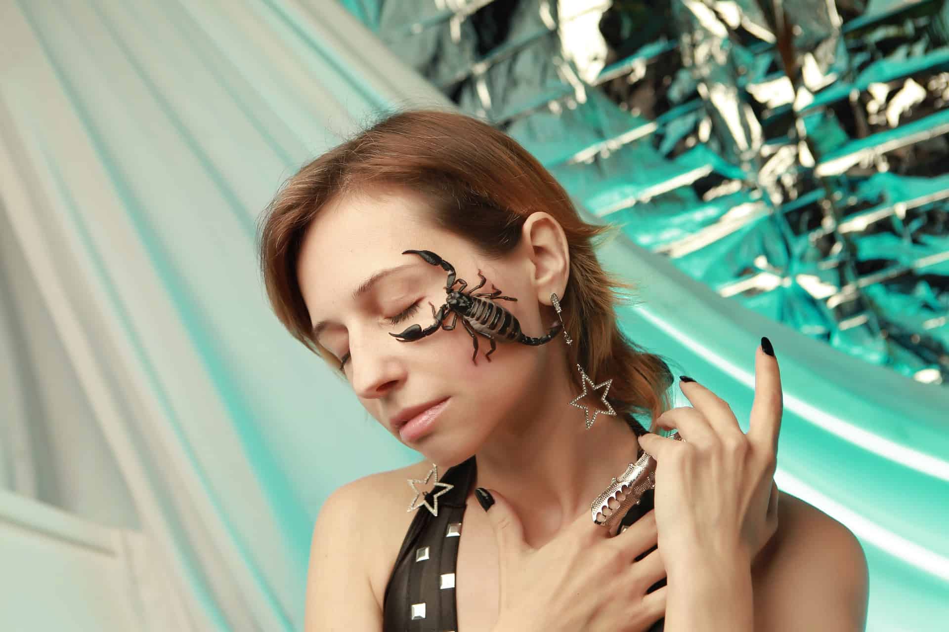 žena so škorpiónom na tvári