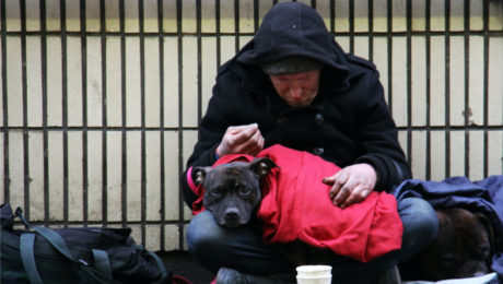 Bezdomovec držiaci v náruči psa