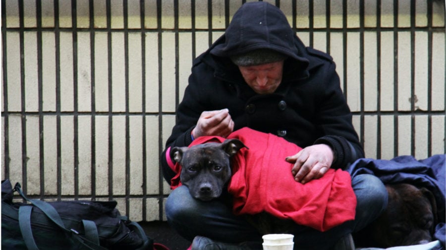 Bezdomovec držiaci v náruči psa