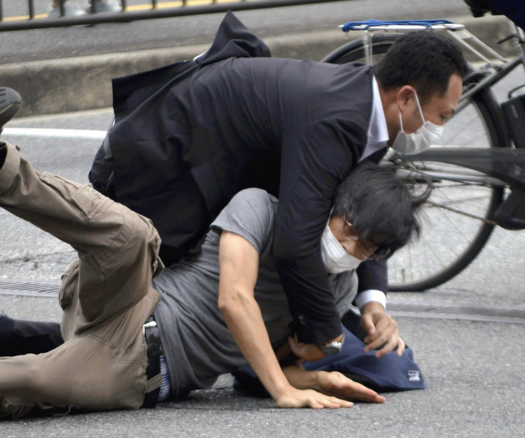 Na snímke dole je útočník Jamagami Tecuja, ktorého spacifikovali a zadržali na mieste bezpečnostné zložky.