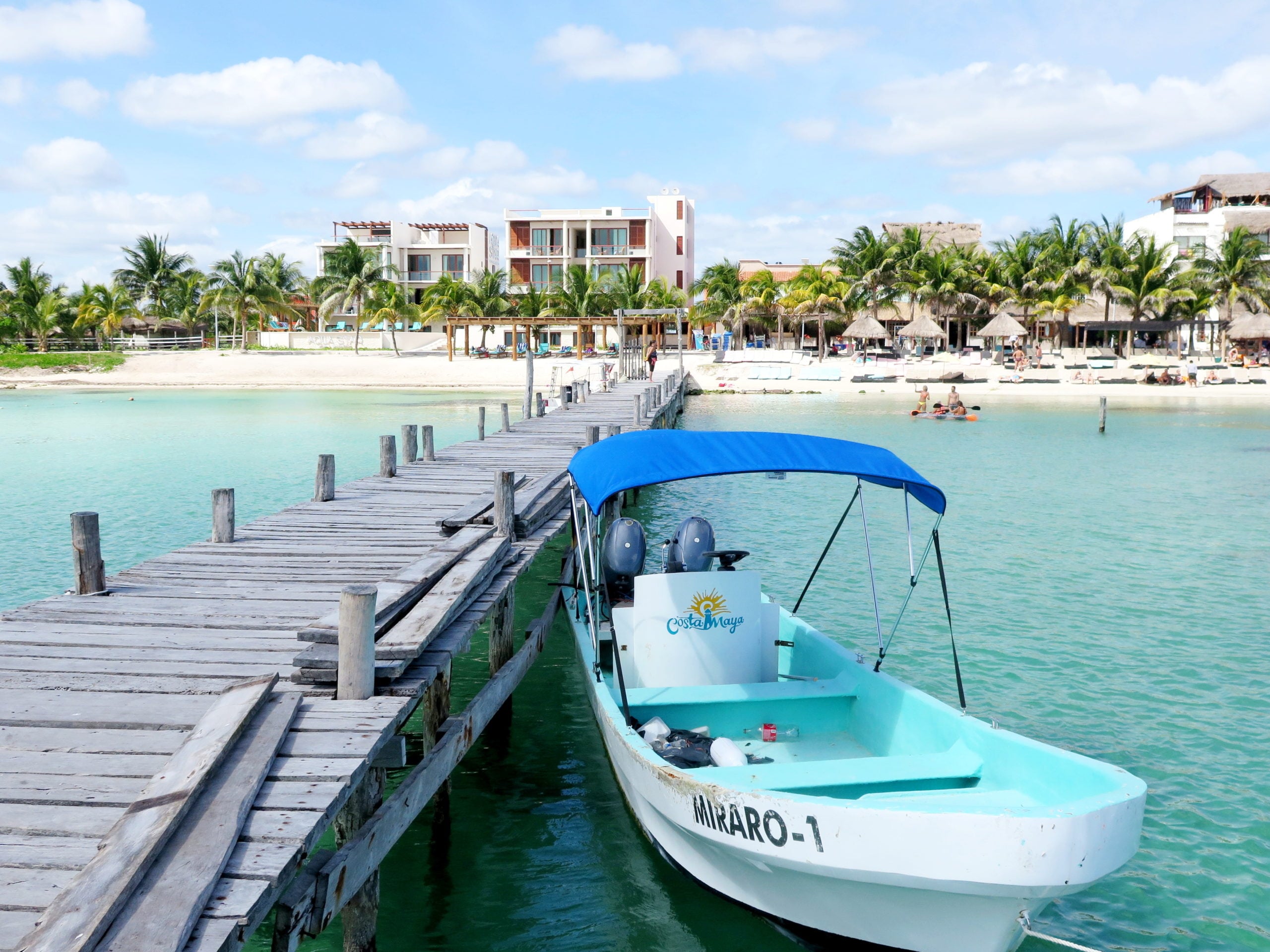 Loď a mólo na mori pred nádhernou bielou plážou v Mexiku