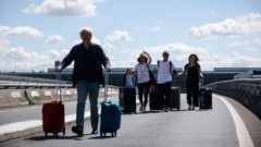 Na snímke sú ľudia s batožinou.