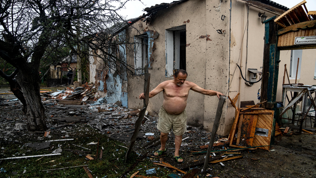 muž stojí pri ruine svojho domu, ktorý zničili ruskí okupanti