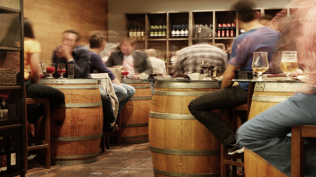 mladí ľudia sedia s priateľmi v pube na poháriku alkoholického nápoja