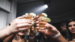 mladí ľudia si na párty pripíjajú s alkoholickým nápojom
