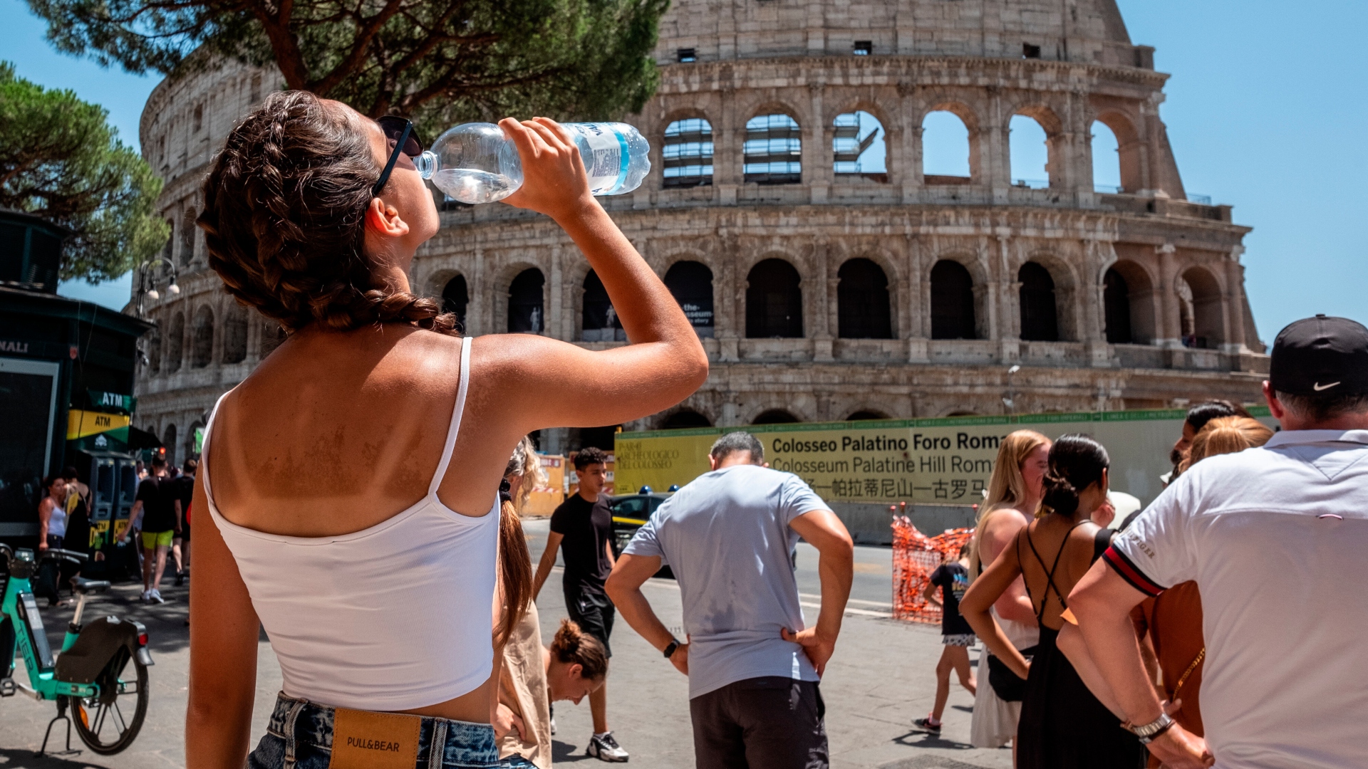 Na snímke žena, ktorá pije v horúčavách vodu.