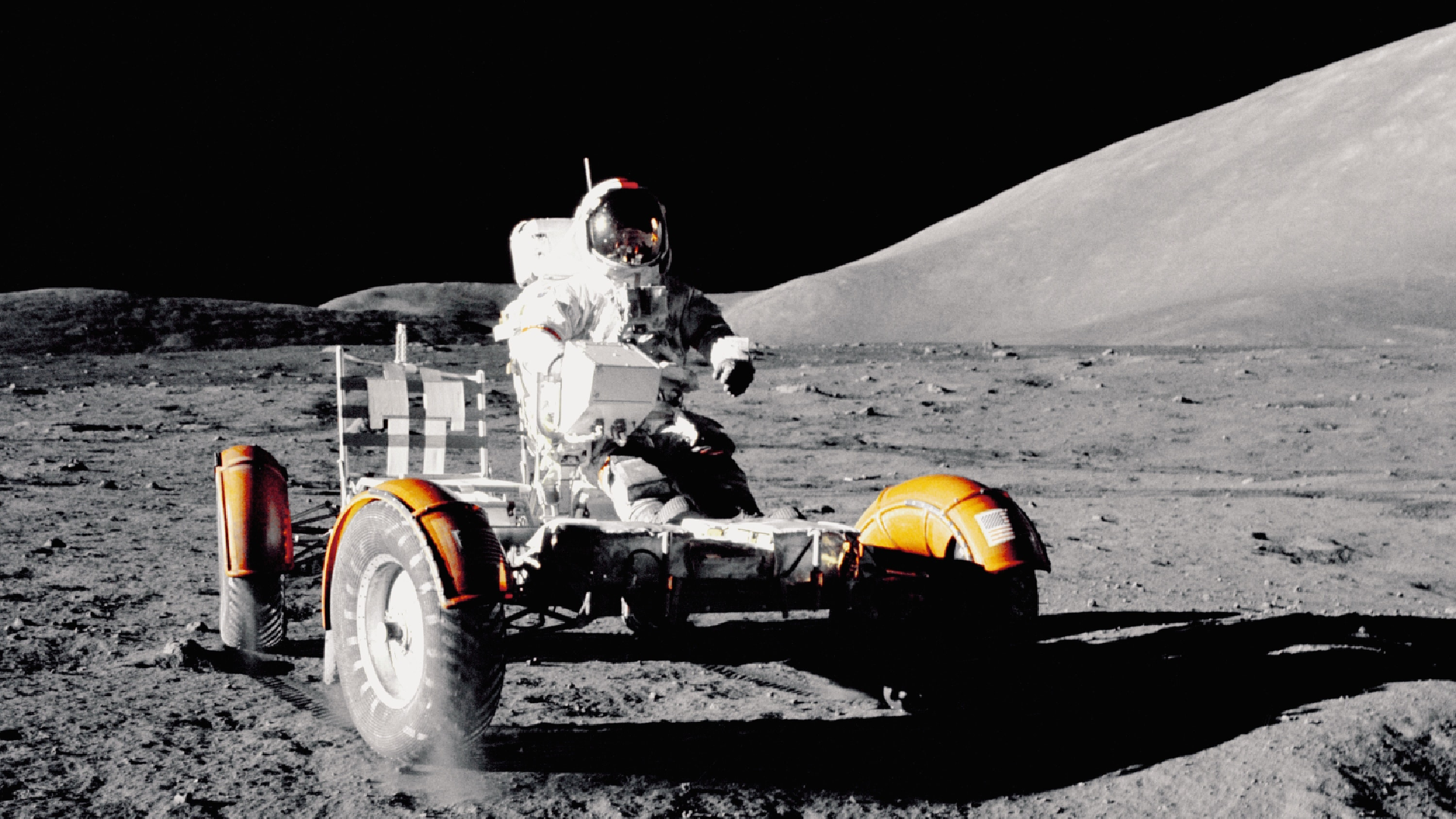 astronaut sediaci vo vozidle na mesačnom povrchu