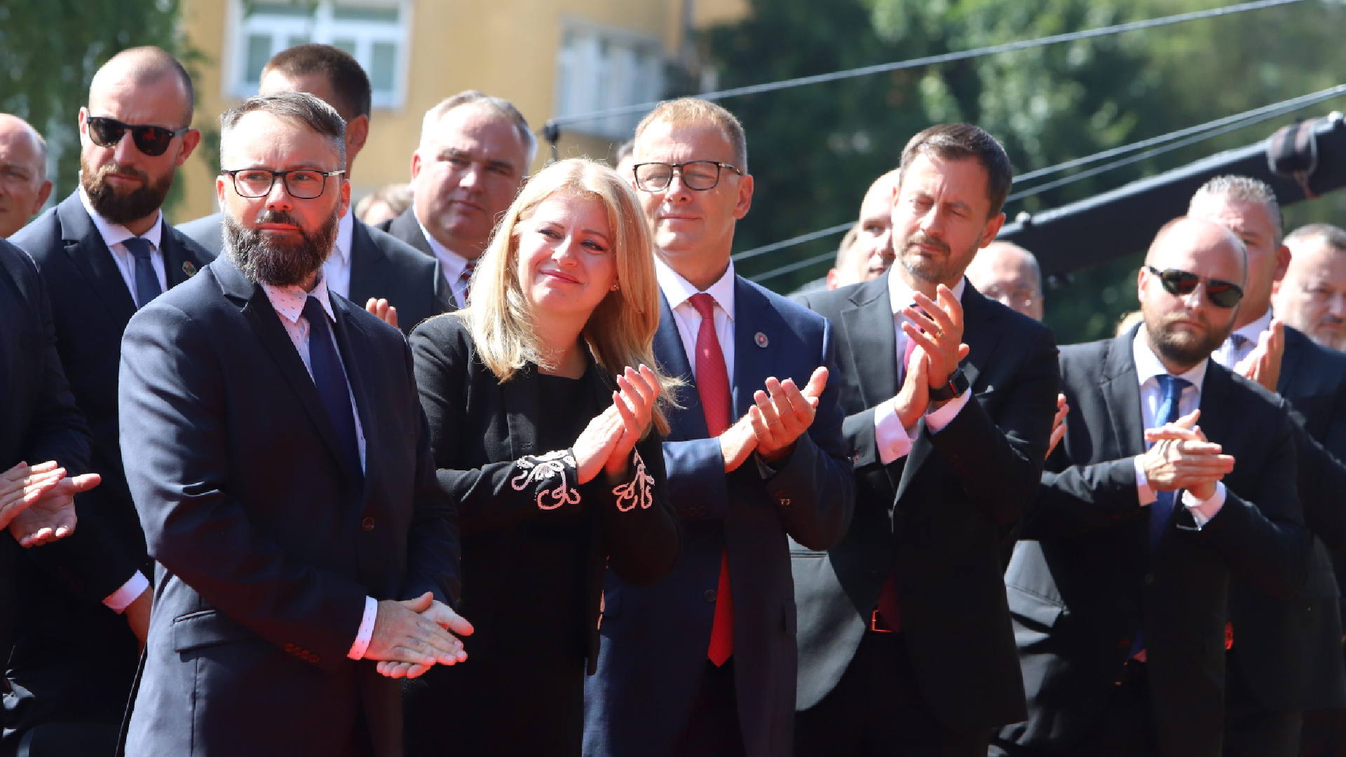 tlieskajúca prezidentka a ministri stojaci v dave