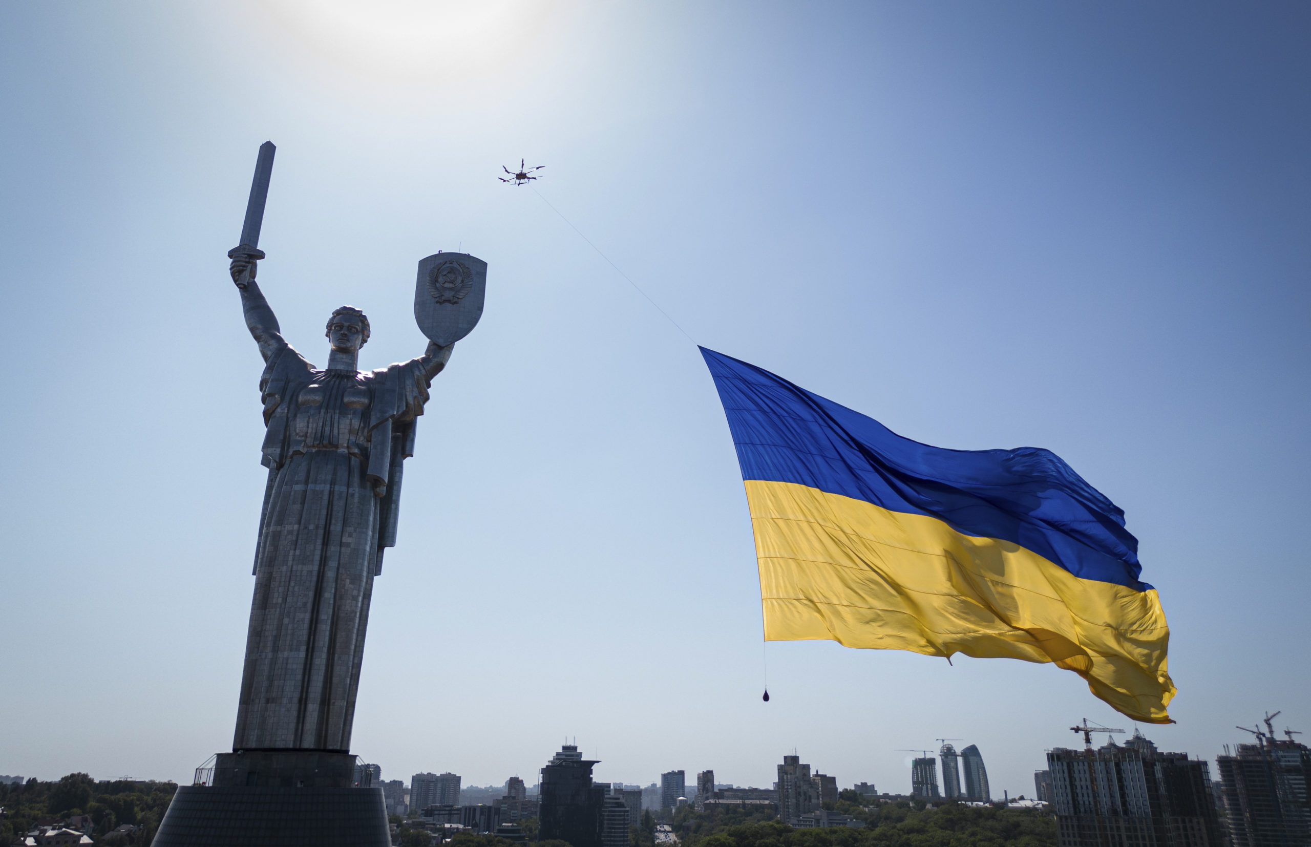 Dron nesie veľkú štátnu vlajku pred ukrajinským Pamätníkom vlasti v Kyjeve v stredu 24. augusta 2022.