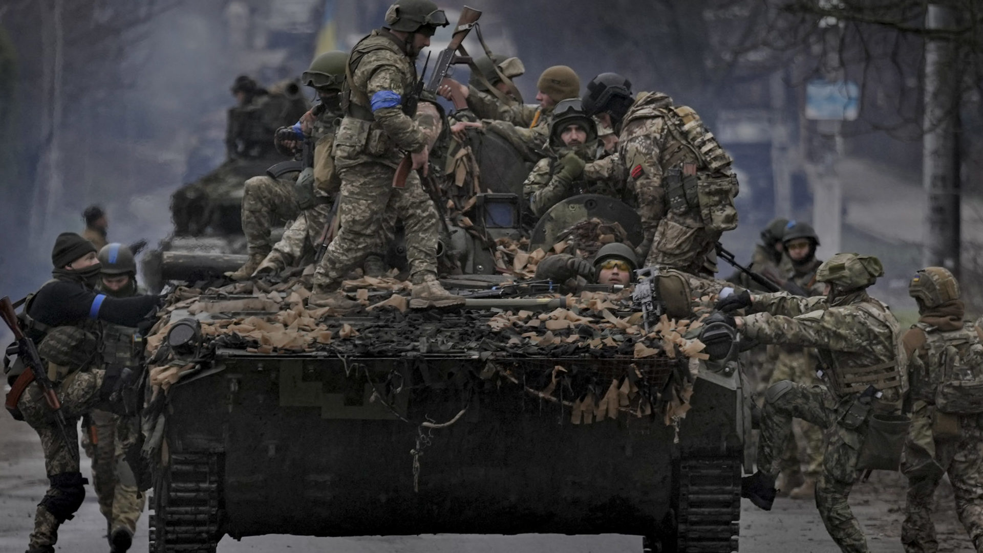 Ukrajinskí vojaci vystupujú na bojové vozidlo pri Kyjeve,