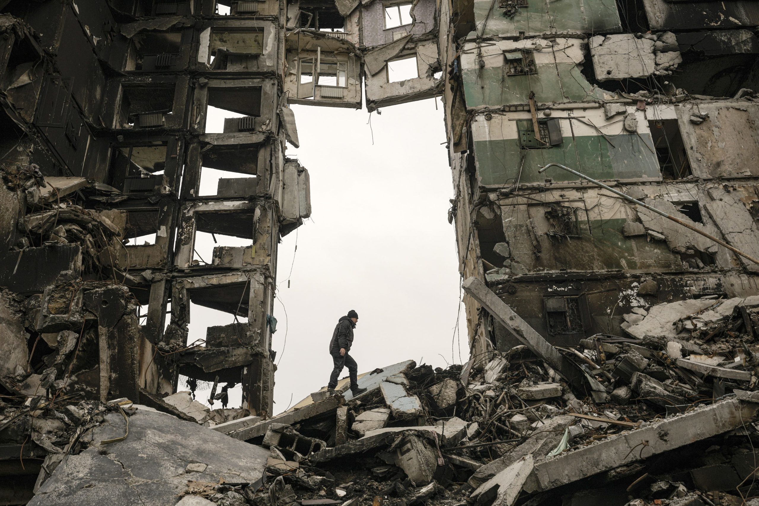 Muž v Borodyanke na Ukrajine hľadá svoje veci v zdevastovanej obytnej budove