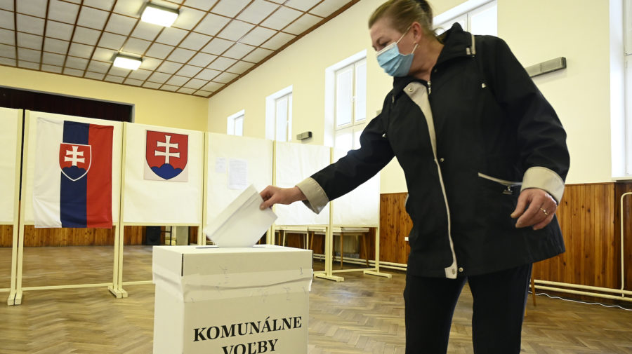 Žena hádže volebný lístok do schránky počas komunálnych volieb v roku 2020