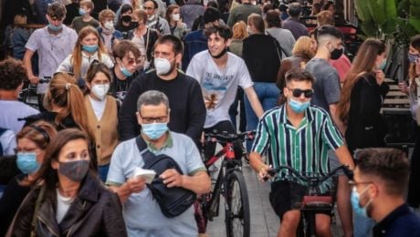 Na snímke je dav ľudí v rúškach.