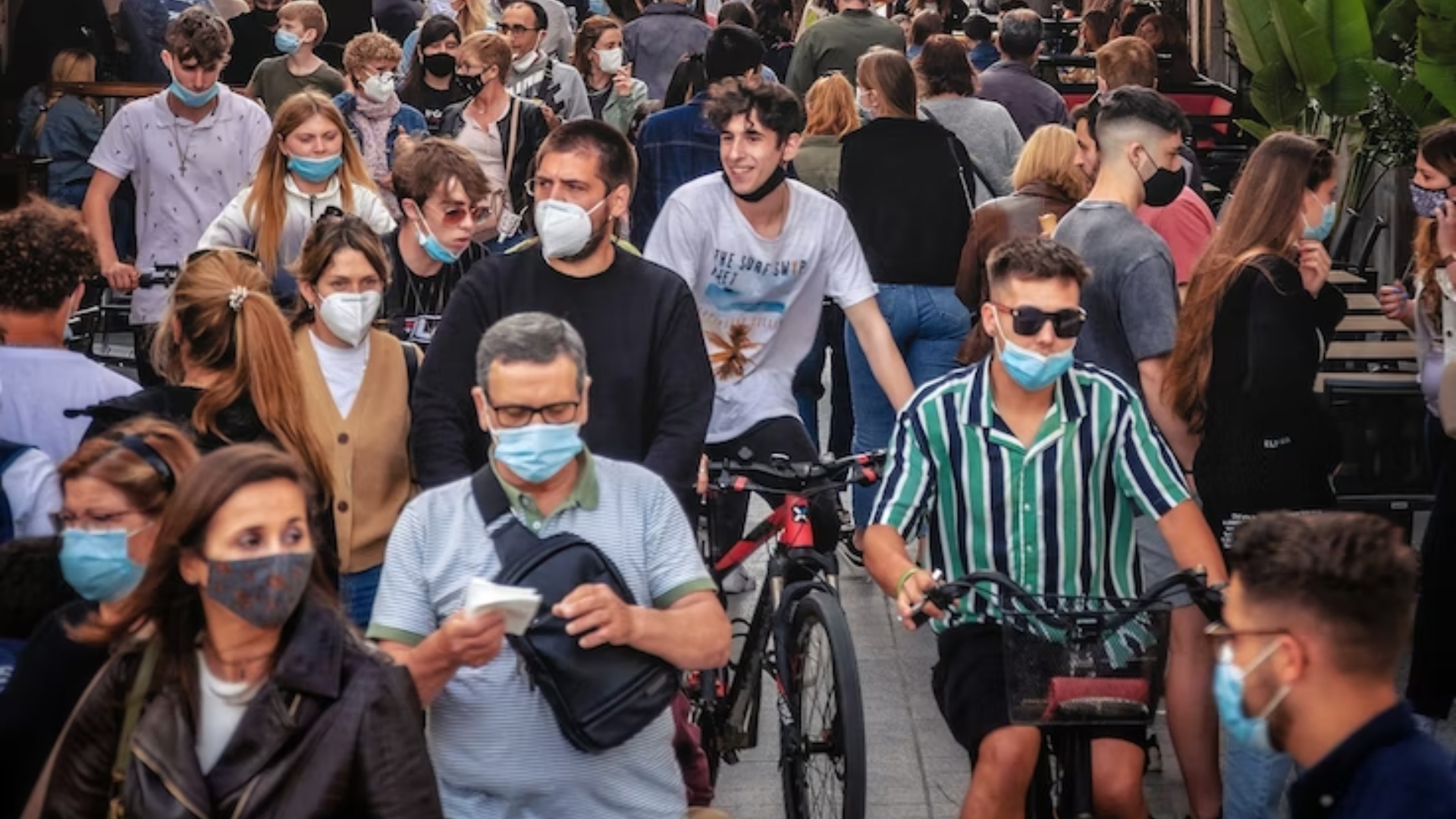 Na snímke je dav ľudí v rúškach.