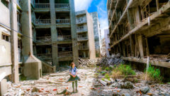 dievča medzi rozbitými budovami