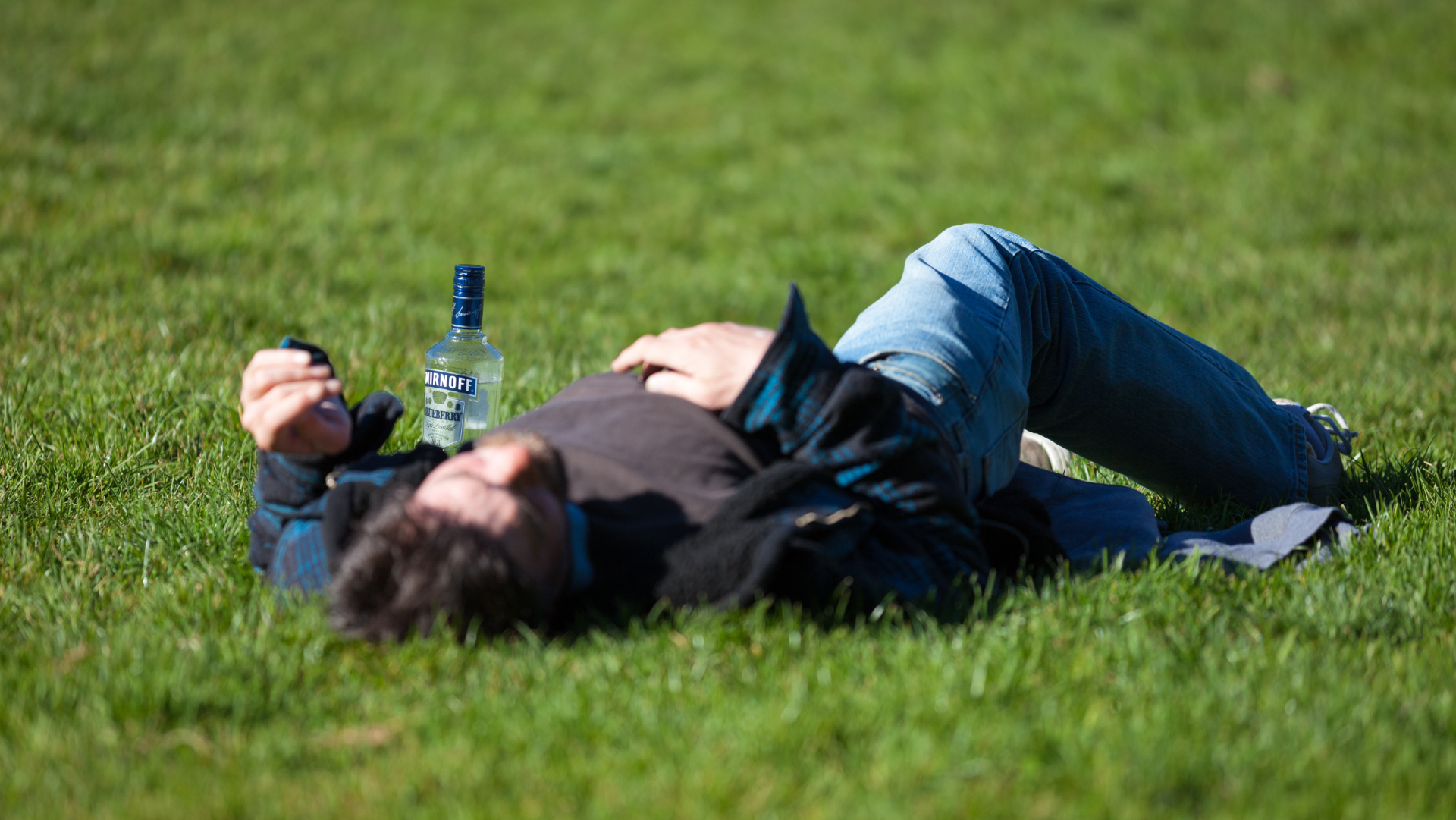 opitý muž ležiaci na tráve