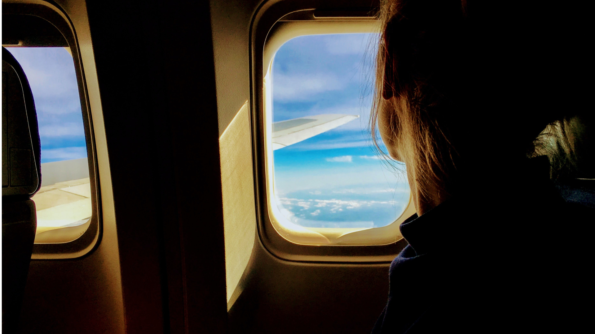 Žena v lietadle pozerajúca sa z okna
