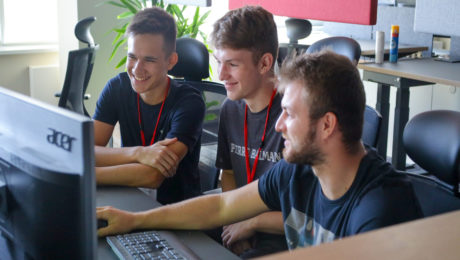 Žiaci sedia za počítačom a smejú sa