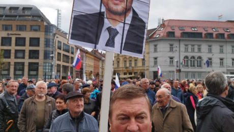 Účastník protestu pred prezidentským palácom s banerom tváre Eduarda Hegera