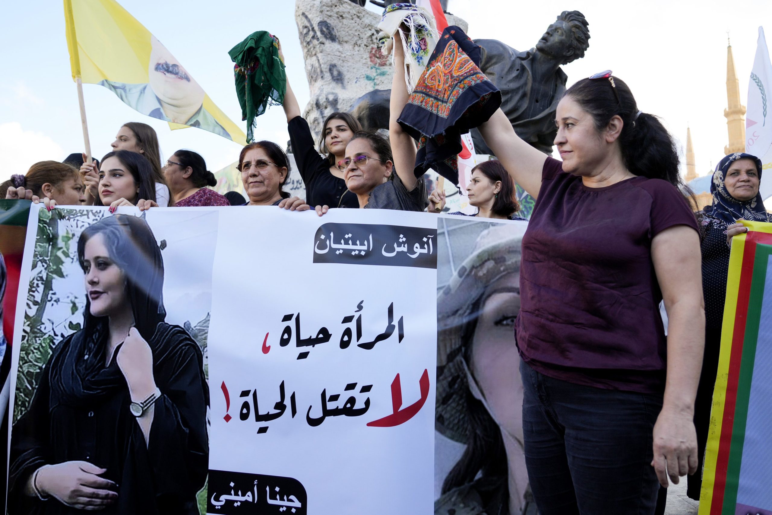 Iránky na proteste držia transparent so zavraždenou Mahsou Amini