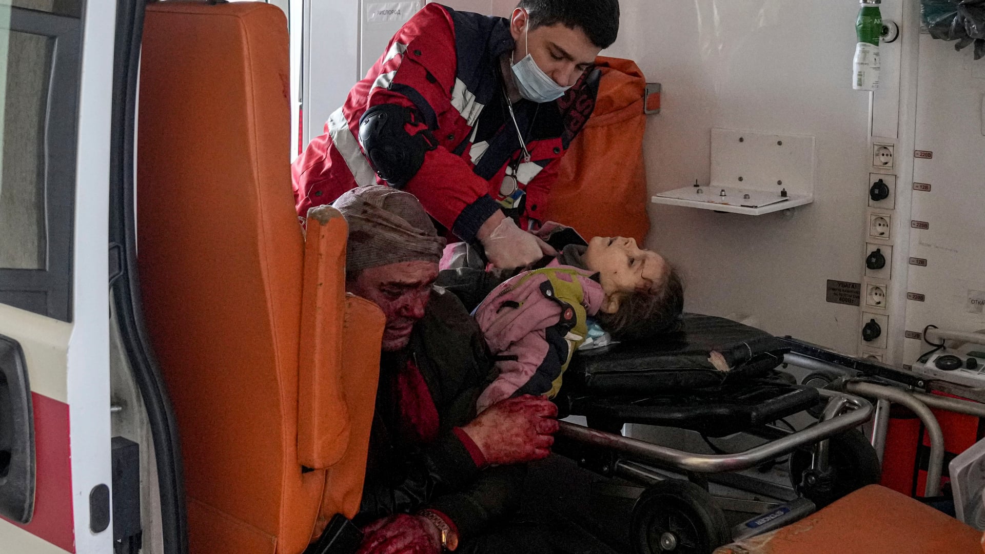 člen záchrannej službe podávajúci prvú pomoc zranenému dievčaťu