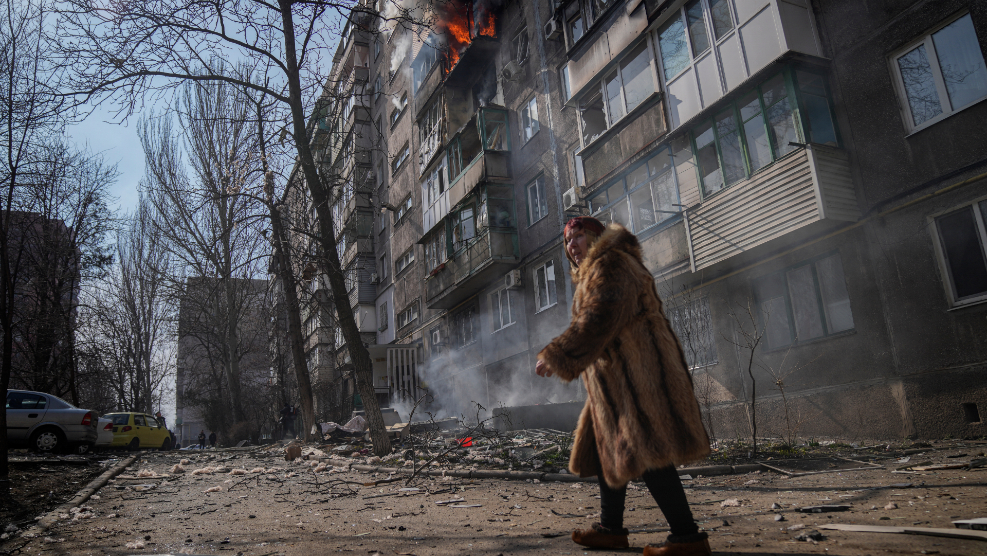 obyvateľka ukrajinského mesta prechádzajúca sa po zničenej ulici