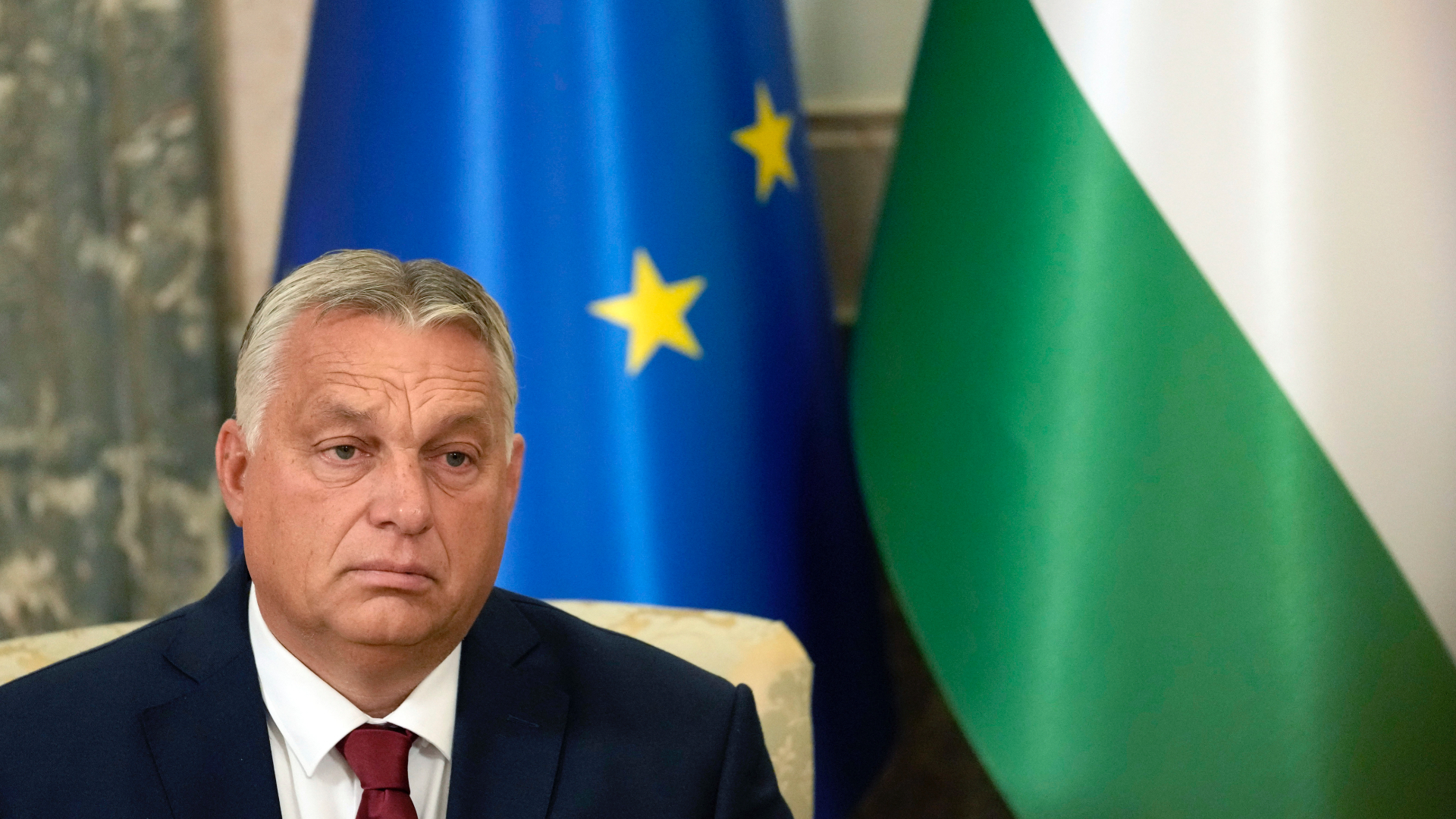 Orbán za vlajkou európskej únie a Maďarska hľadí zarmútene