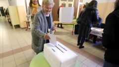 Volička vhadzuje obálku s referendovým lístkom do volebnej schránky. Na Sliači sa koná referendum o odmietnutí vojenskej základne.