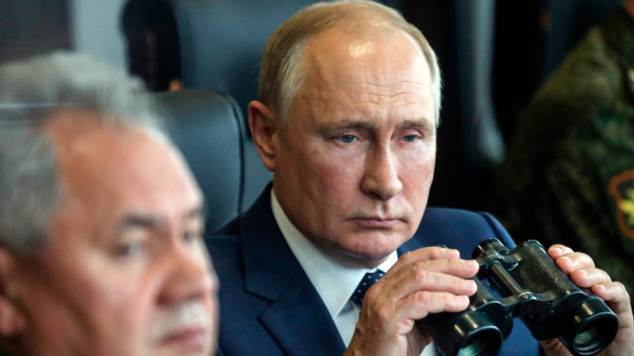 Vladimir Putin, v pozadí Sergej Šojgu