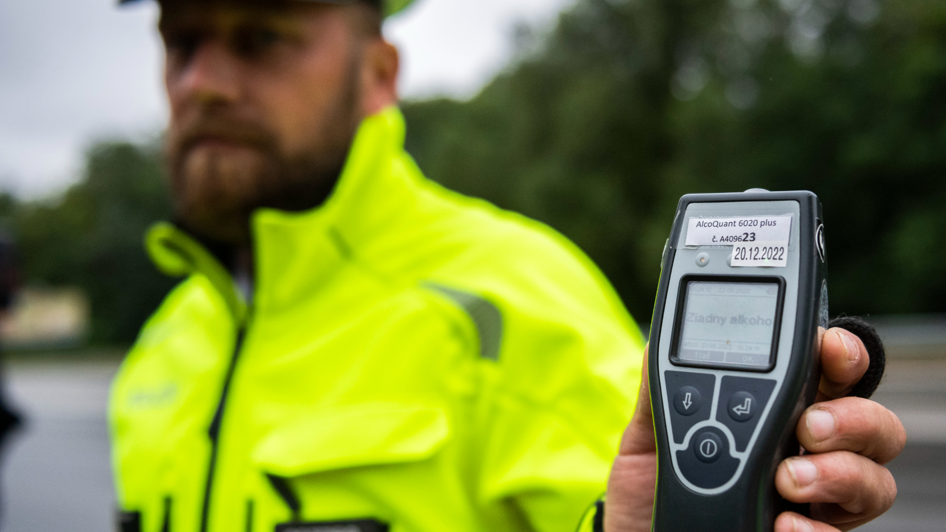 Policajt ukazuje výsledok kontroly vodiča na prítomnosť alkoholu