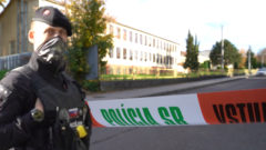 Policajt a policajná páska pred strednou školou