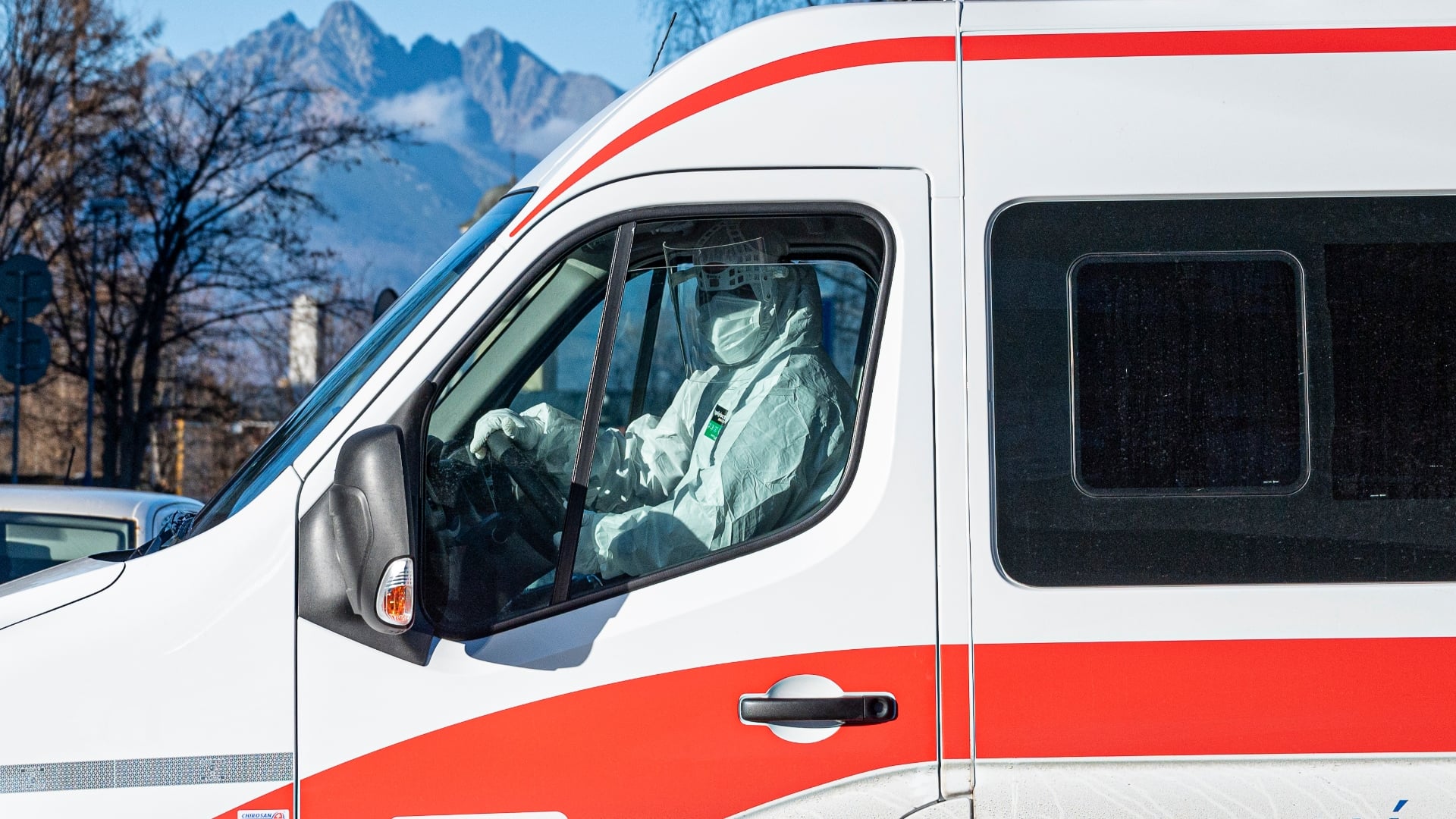 Na snímke je sanitka a zdravotník.