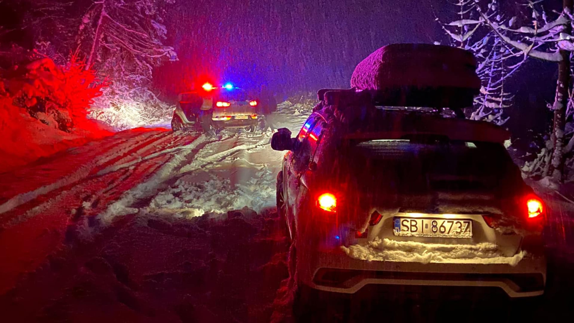 Cestári a policajti na zasneženej ceste. Cesty a prechody uzavreli