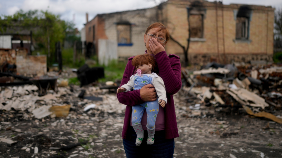 Nila Zelinská drží bábiku svojej vnučky nájdenú v jej zničenom dome.