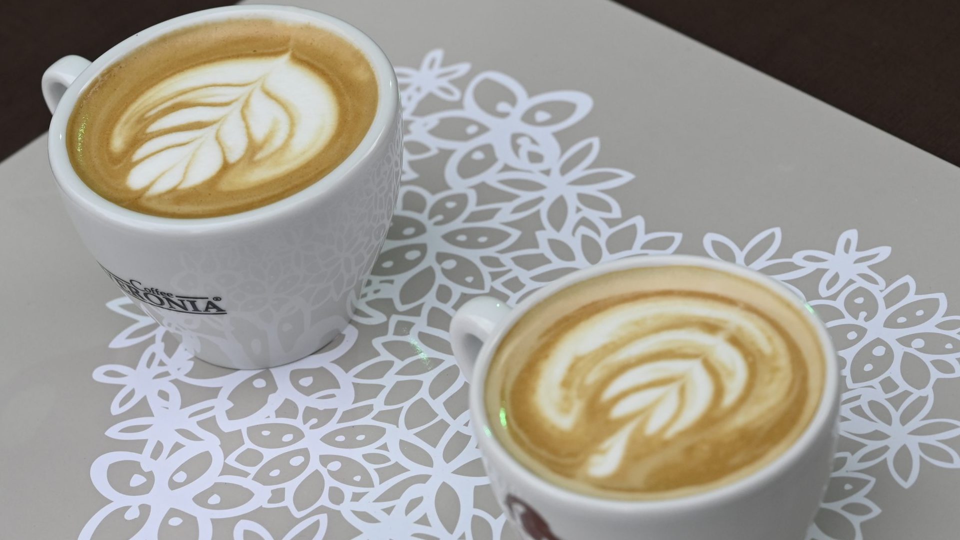 Na snímke sú dve šálky kávy položené na stole.