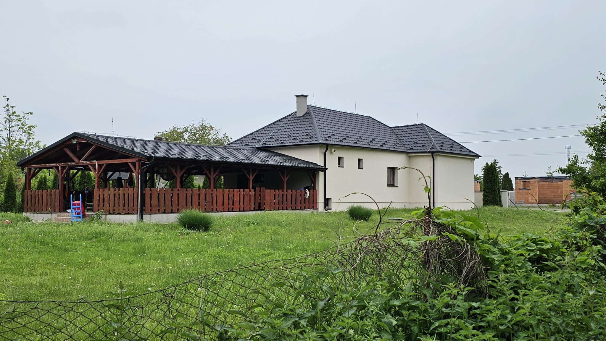 Rodinný dom v Trávniku a za ním veľká terasa, na ktorej zavraždili podnikateľa Tibora Szűclsa.