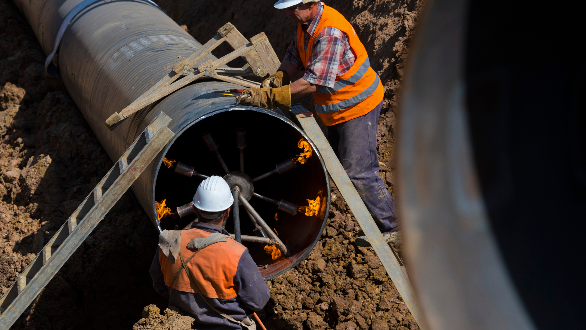 Plynovod, ktorý opravujú pracovníci v pracovnom odeve