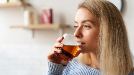 Žena pijúca nápoj z pohára.