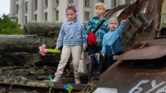 Zničený ruský tank, na ktorom stoja deti Ukrajincov