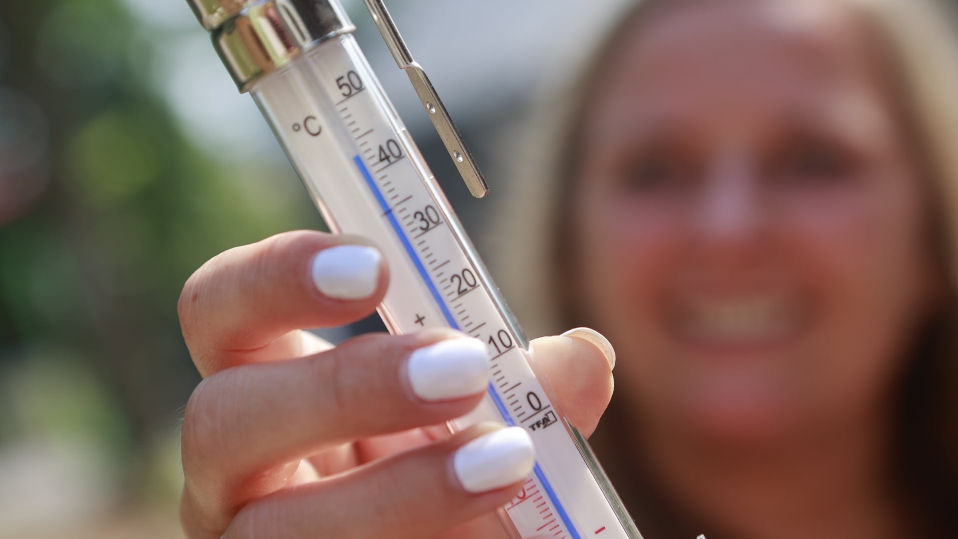 Na snímke žena drží teplomer, ktorý ukazuje 45 stupňov Celzia