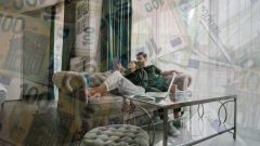 Mladý pár oddychuje na gauči a peniaze