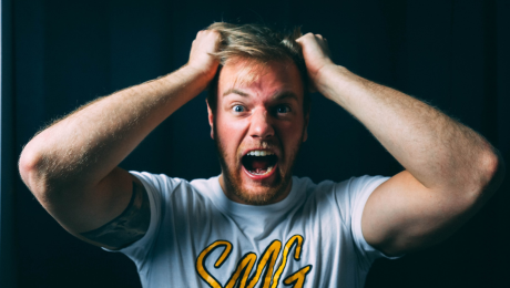 Nahnevaný muž sa ťahá za vlasy