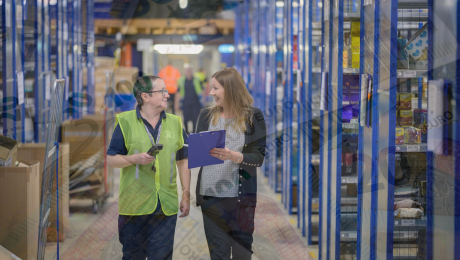 Zamestnankyňa sa zhovára v sklade so ženou a spoločne sa smejú.